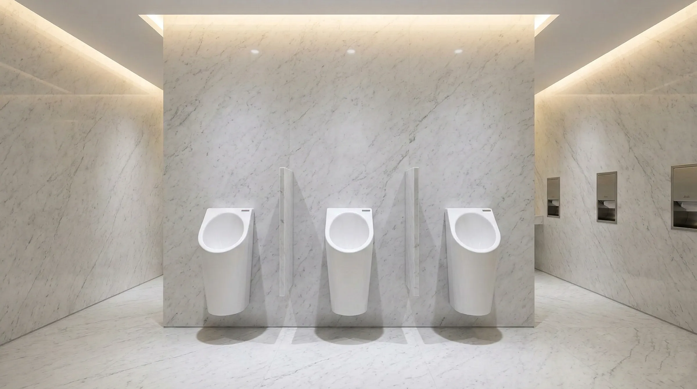 Drei Senza Aqua Urinale in einem hellen Marmor-Waschraum